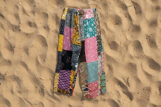Colorful patchwork pants on a sandy surface