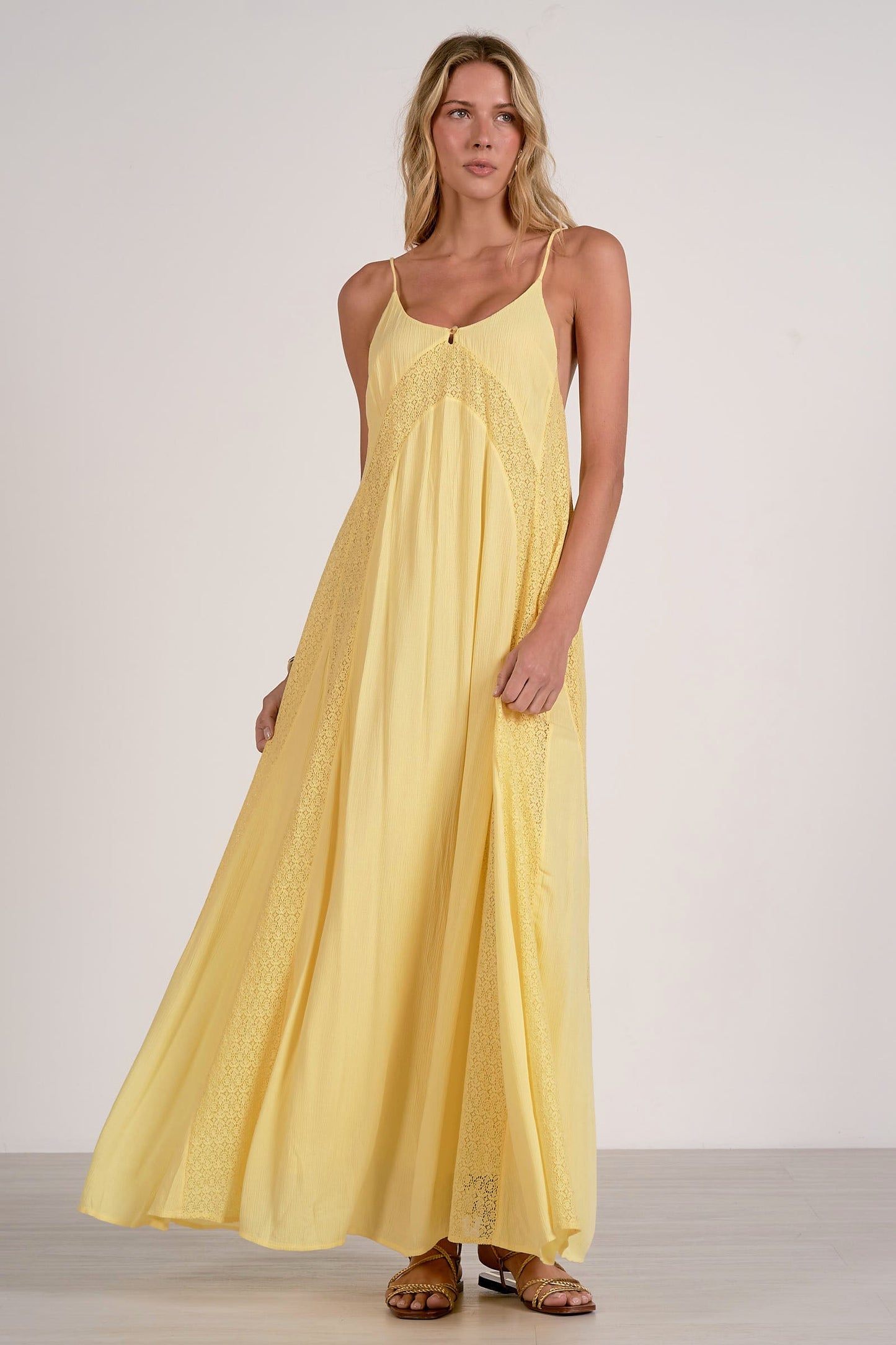 Woman wearing a yellow dress against a plain background