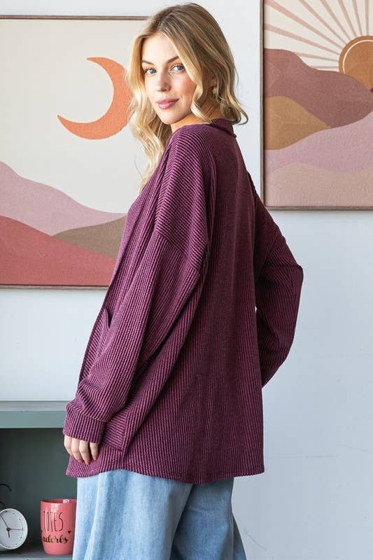 Woman wearing a purple sweater in a room with abstract wall art