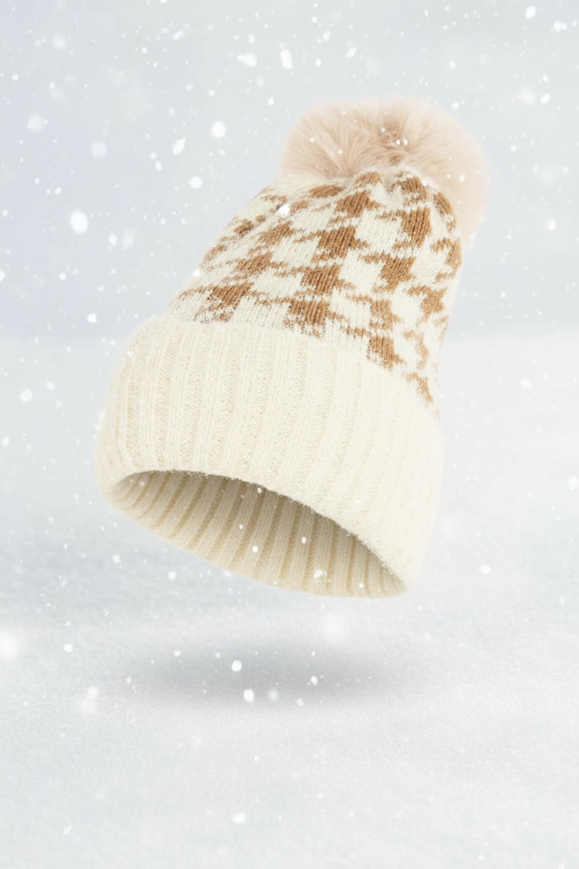 Knitted beanie with a checkered pattern and pom-pom on a beige background
