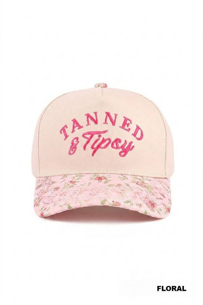 Pink cap with floral brim and embroidered text on a white background