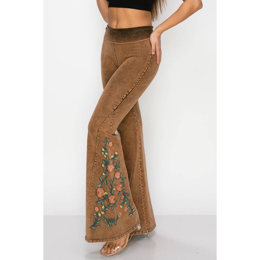 Brown flared pants with floral embroidery on a white background