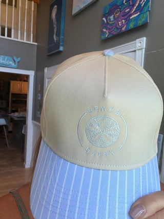 Beach Gypsy Blue & White Stripe Trucker Hat shown front-facing to display its embroidered patch and two-tone panel design