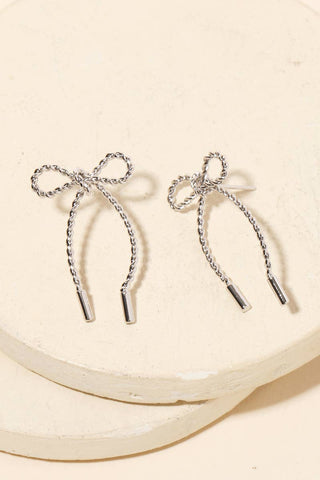 Close-up of Bow Tie Earrings dangle earrings laid flat, showing their beaded detail