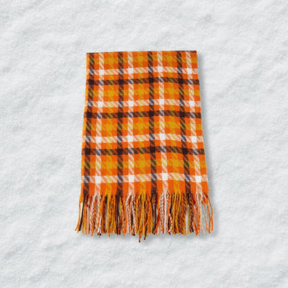 Plaid scarf with orange, yellow, and black pattern on a beige background