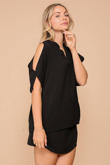 Woman wearing a black outfit against a beige background