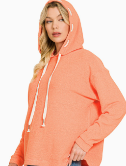 A woman wearing a heathered coral orange pullover hoodie with white drawstrings, shown against a plain white background.