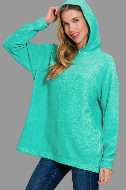 Woman wearing a turquoise hoodie on a white background