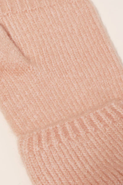 Close-up of a pink knitted sock with visible texture on a light background