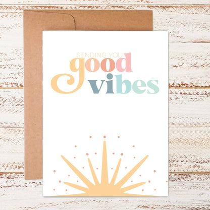 Card with 'Sending you good vibes' text on a wooden surface