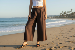 Woman wearing brown flowy pants on a beach