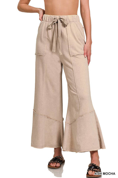 Beige wide-leg pants worn by a person on a white background