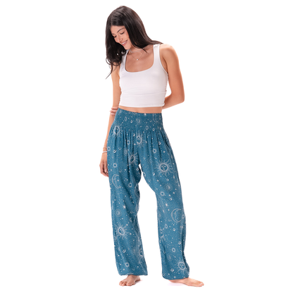 Woman wearing blue patterned pants and a white top on a white background