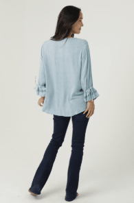 Light Blue Ruffle Sleeve Lace Up Neck Top laid flat or shown on a model, highlighting its boho fabric and neckline in blue