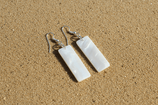 Close-up of Seafoam Shell Dangle Earrings dangle earrings laid flat, showing their seafoam detail