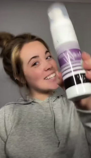 girl smiling and holding tanning products